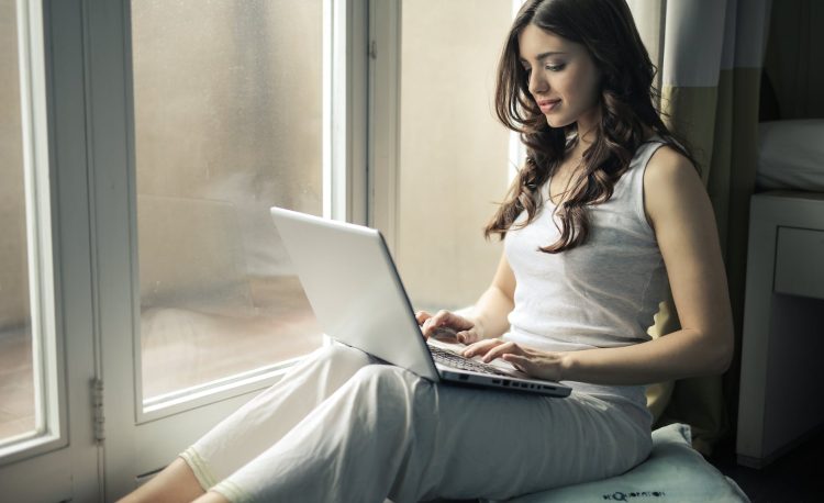 woman wearing tank top sitting by the window
