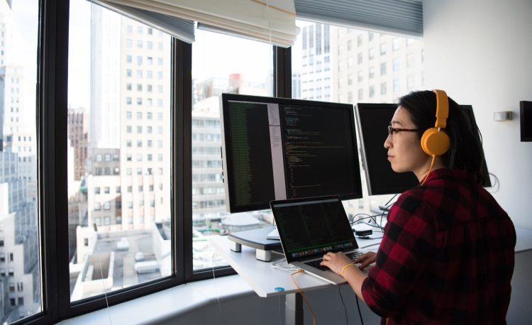 woman sitting while operating macbook pro
