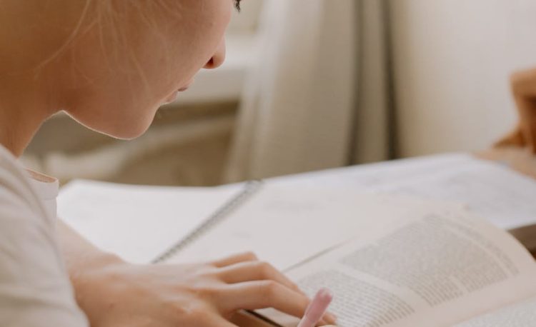 girl in white shirt reading book