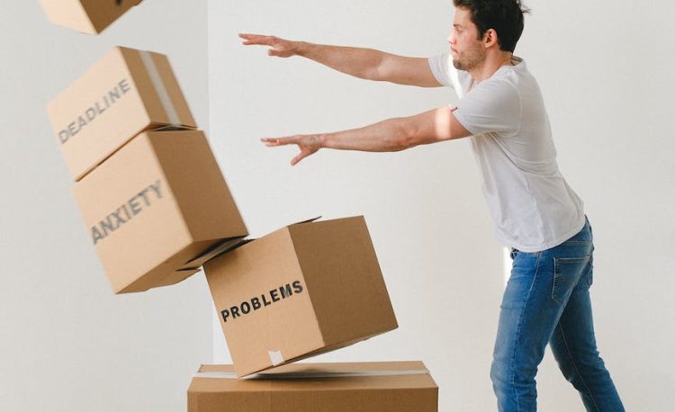 man falling carton boxes with negative words