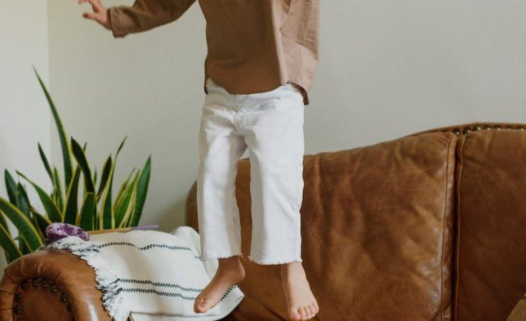 excited girl jumping on couch in living room