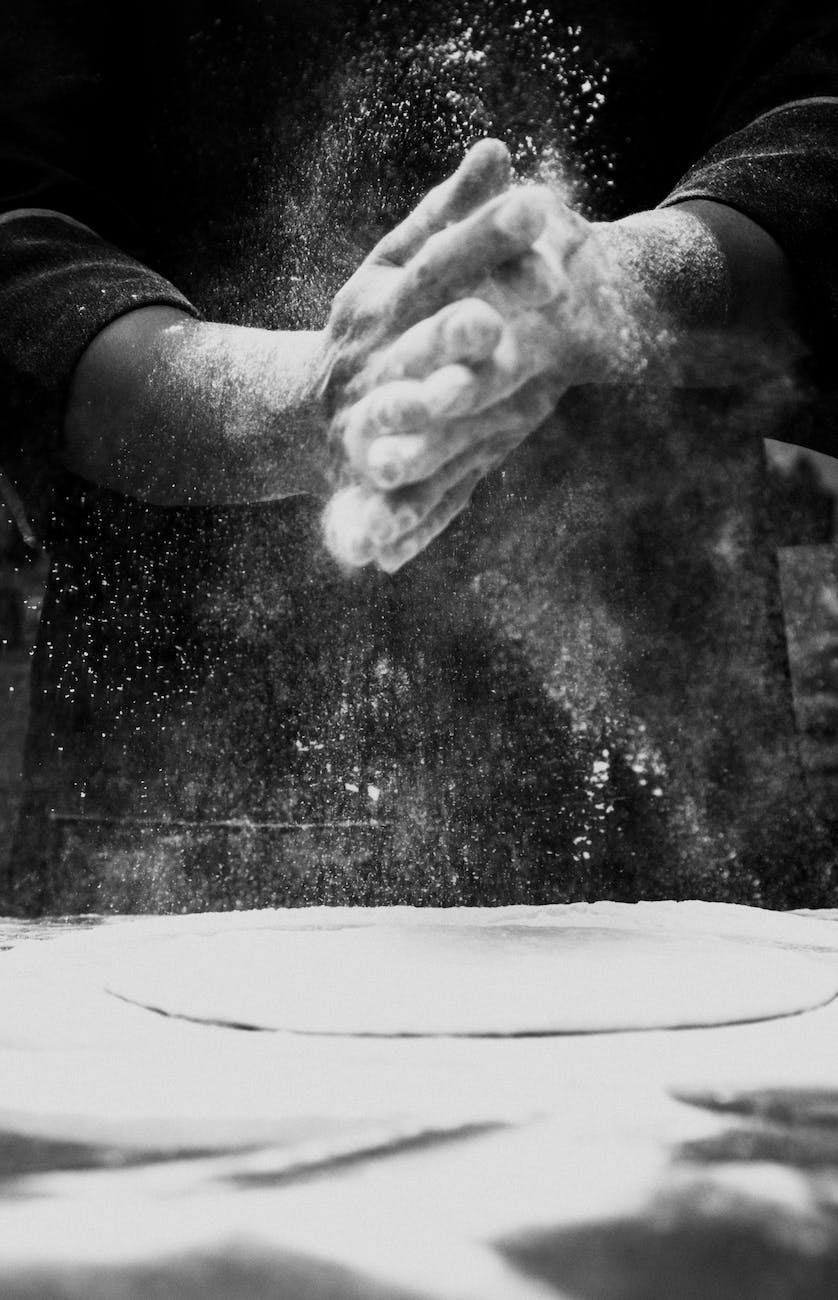 person spreading flour