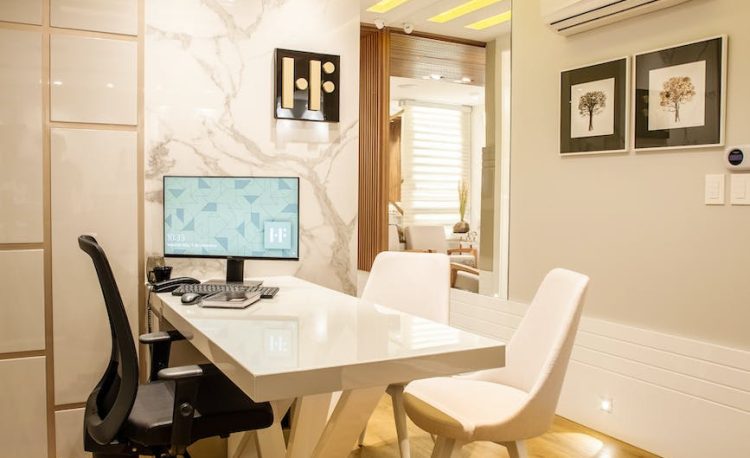 turned on black flat screen monitor on white wooden table and chairs