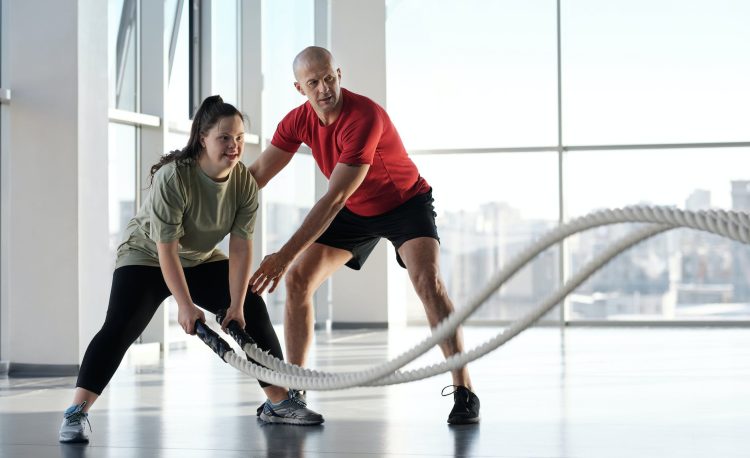 a woman holding ropes beside a trainer