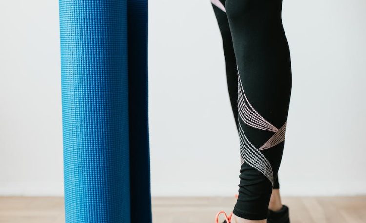 crop sportswoman with fitness mat