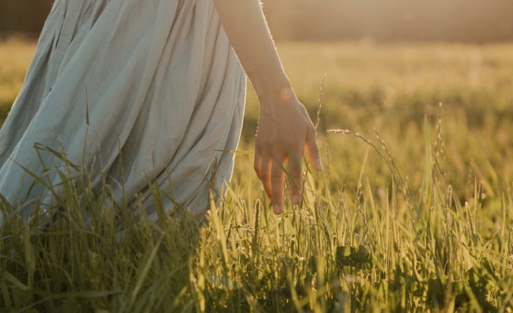woman in white dress standing on green grass field