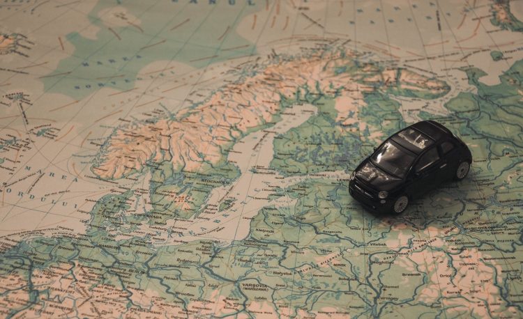 black toy car on world map paper