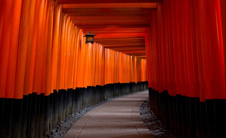 gray concrete pathway between red and black pillars