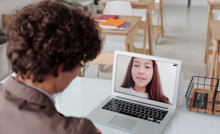 a teacher talking to her student using a laptop